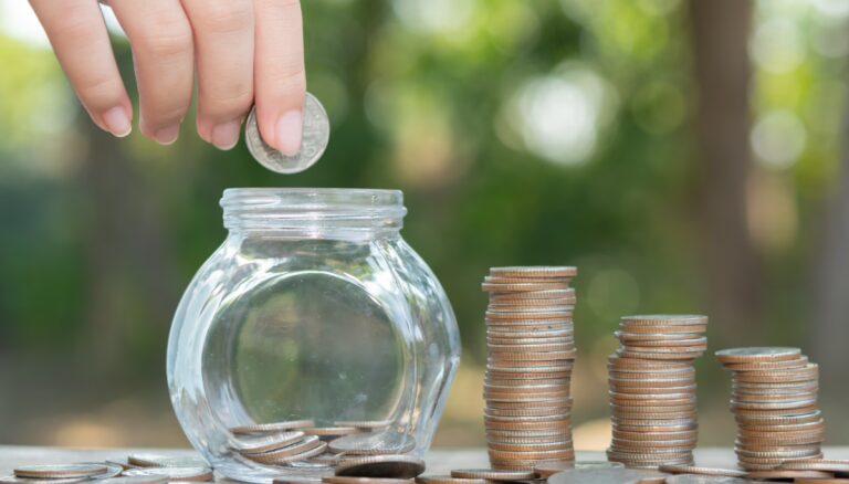 A person adding money into a box, symbolizing the process of saving for an emergency fund.